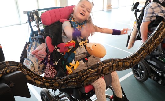 Young girl smiling with a snake.