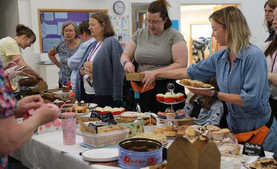 People waiting to be served at a bake sale.