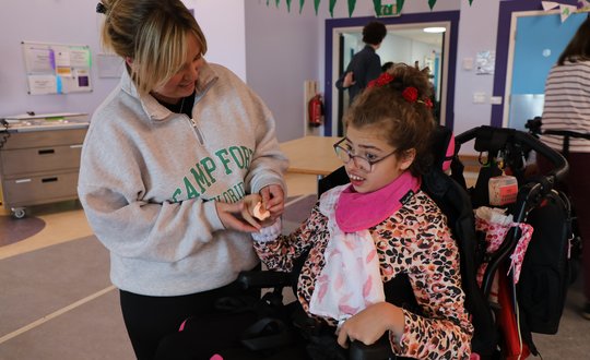 Girl smiling at her handmade flower.