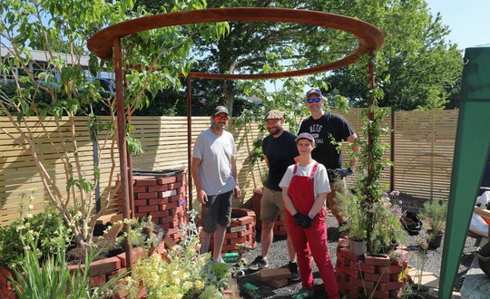 people standing in a garden.