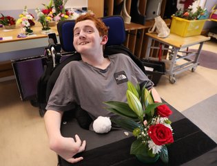 Boy smiling with his flower arrangements.