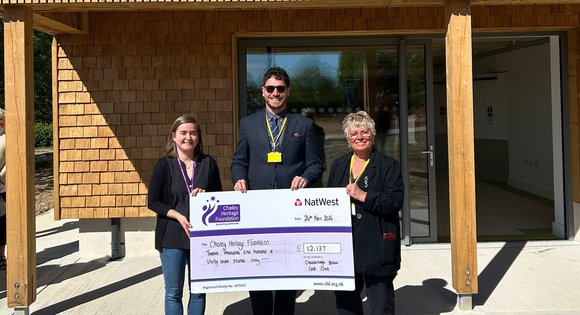 Two women and a man presenting a cheque.