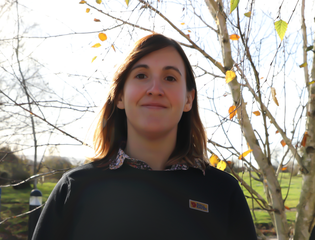 Woman smiling in front of trees