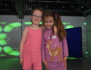 Two young girls with their arms around each other.