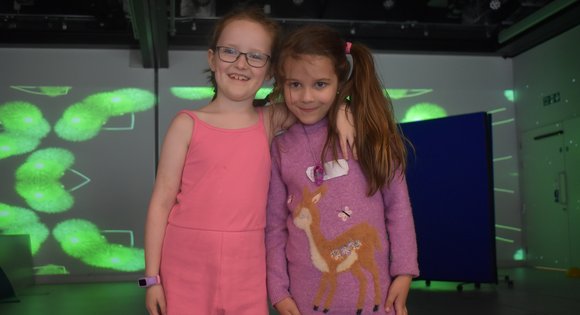 Two young girls with their arms around each other.
