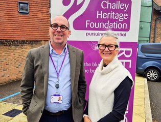 Emma and Gareth standing in front of a Chailey Heritage Foundation sign