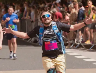 Man running smiling at the camera.
