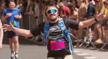 Man running smiling at the camera.