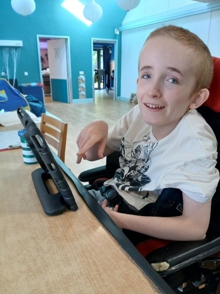 Boy using his iPad at the table.
