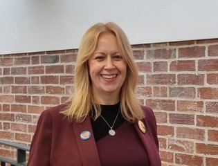 Women smiling with pink top. 