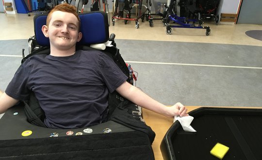 Boy smiling up at the camera.