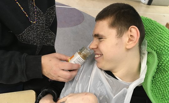 Boy smelling a spice while smiling.