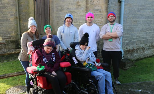 Group of men and women with young people all posing for a photo outside.