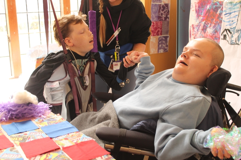 Two young people smiling at each other in an art session.