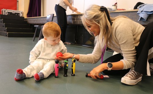 Young boy playing with a mini bowling yet.