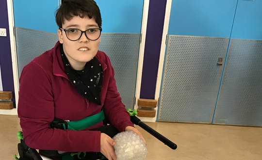 Young person playing with bubble wrap.