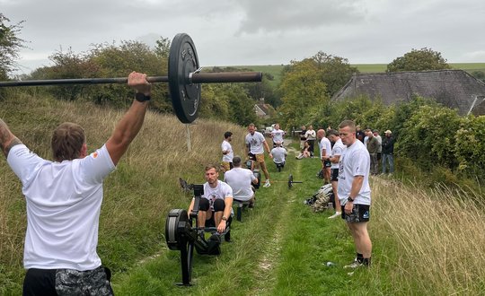 Men working out, outside with matching tops on.