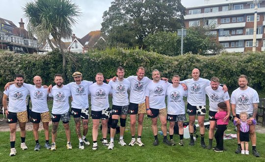 Men in a row taking a photo after their challenge.
