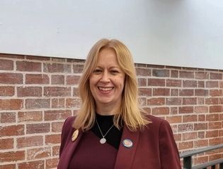 Women head shot wearing a red blazer.
