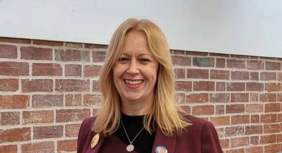 Women head shot wearing a red blazer.