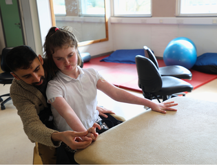 Man helping a girl with hand movements.