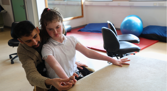 Man helping a girl with hand movements.