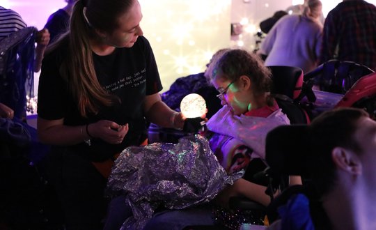 Girl playing with sensory lights and materials.
