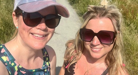 Two woman standing together outside and smiling