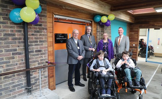 A group of people smiling at an opening.