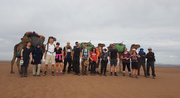 A group of people and camels in the Sahara Desert