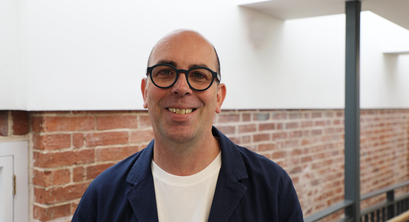 Man smiling with glasses.