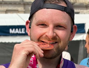 Man biting a medal.