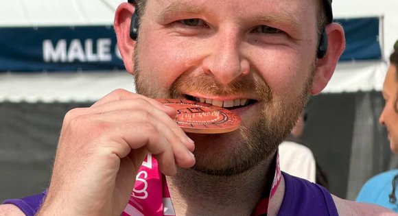 Man biting a medal.