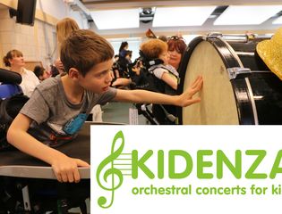 Young boy reaching out to touch drum