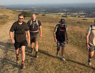 4 men smiling walking up the downs.