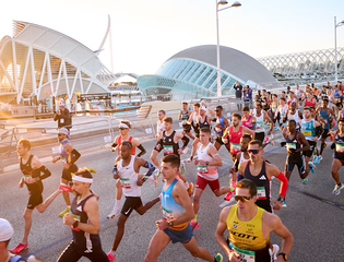 Crowd of runners running through Valencia at sunrise
