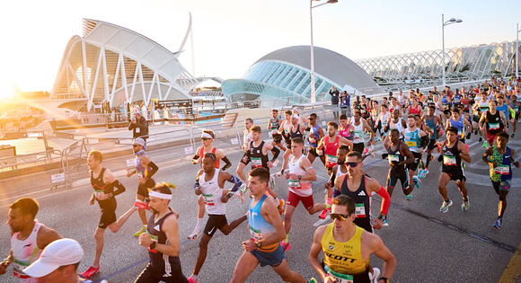Crowd of runners running through Valencia at sunrise