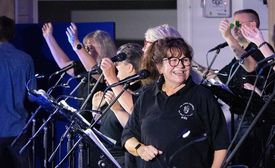 Women standing up on stage smiling.