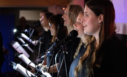 A group singing on stage.