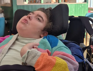 Young person wearing a colourful cardigan.