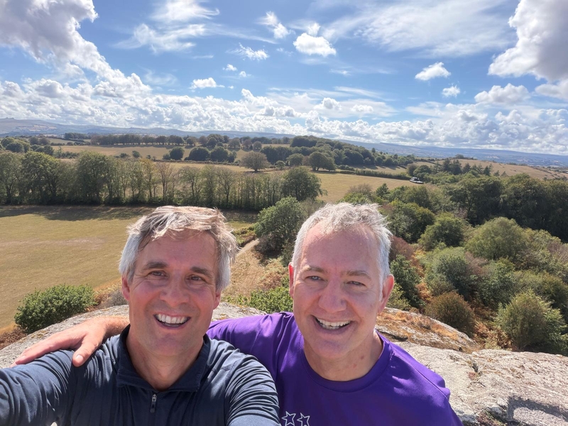 Two men taking a photo with a view point behind them.
