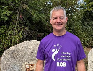 Man with a purple top smiling on a walk.