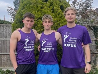 Three boys smiling together wearing purple Chailey tops.