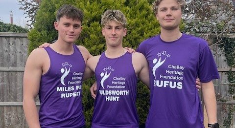 Three boys smiling together wearing purple Chailey tops.