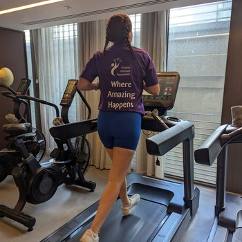Girl running on a treadmill with a Chailey top on.