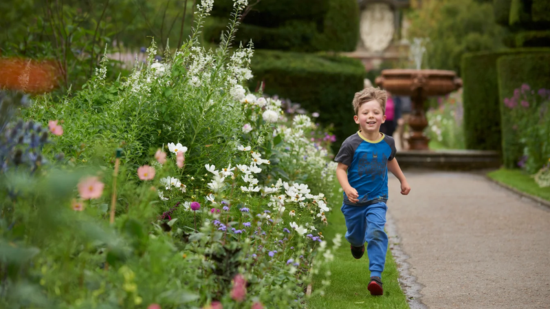 Child running through gardens