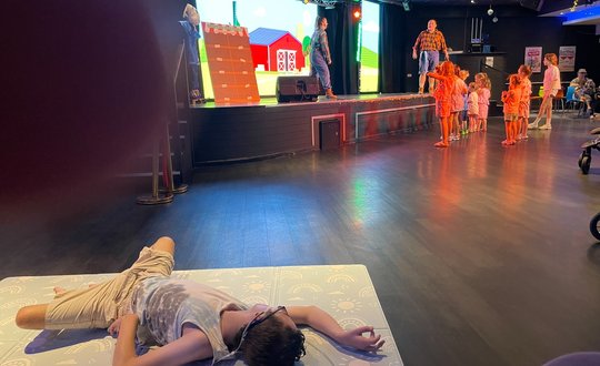 Boy laying on the floor while watching a show.
